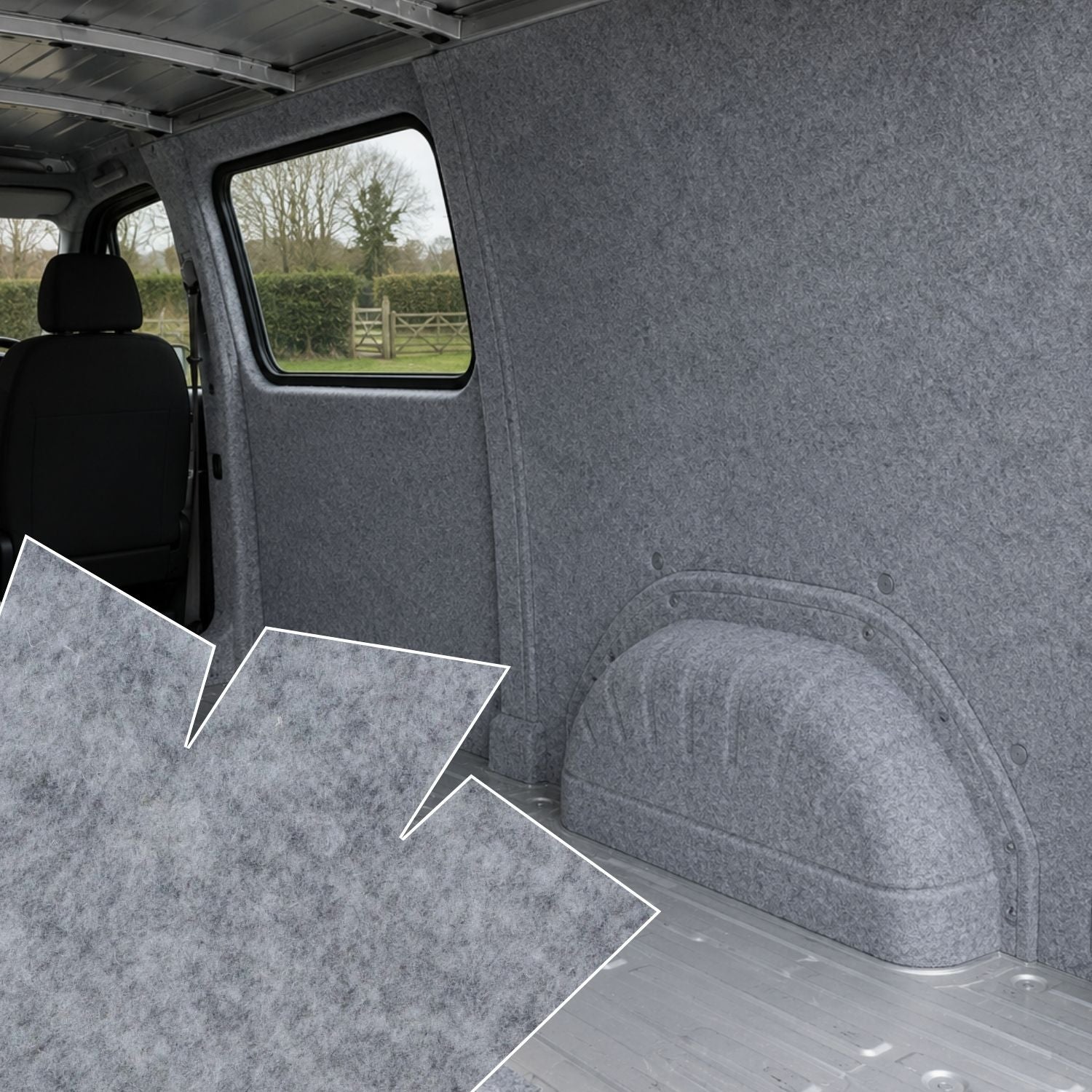 Gray interior of a vehicle with carpeted floor and walls, showing a view through the window.
